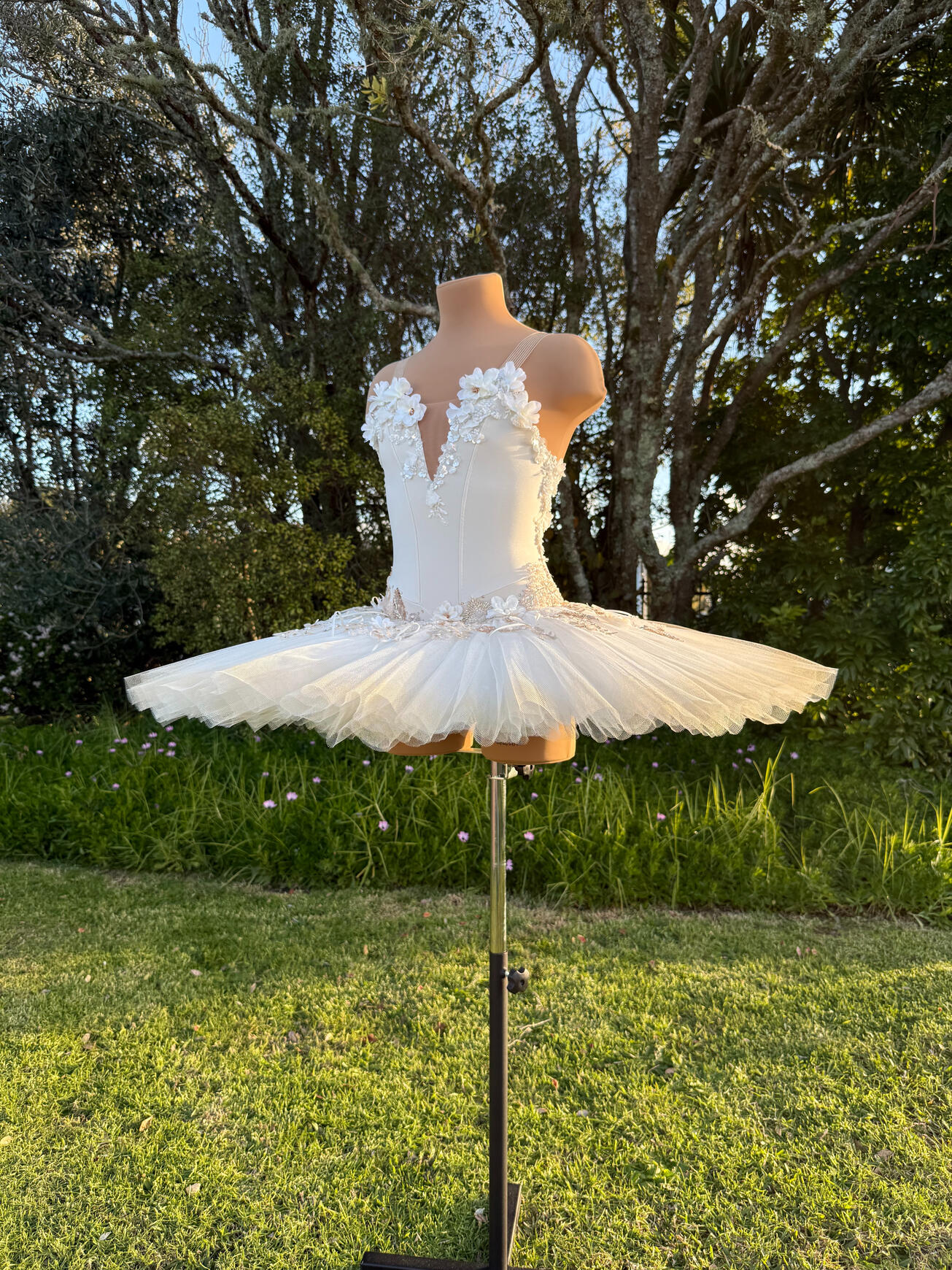 White and Gold Stretch Tutu Stretch tutu with hand-rolled pleats, stiff net, 3D florals, rose gold, bronze and gold beaded lace and hand-sewn bows with smattering of rhinestones. Net edges have an airbrushed gold ombré.