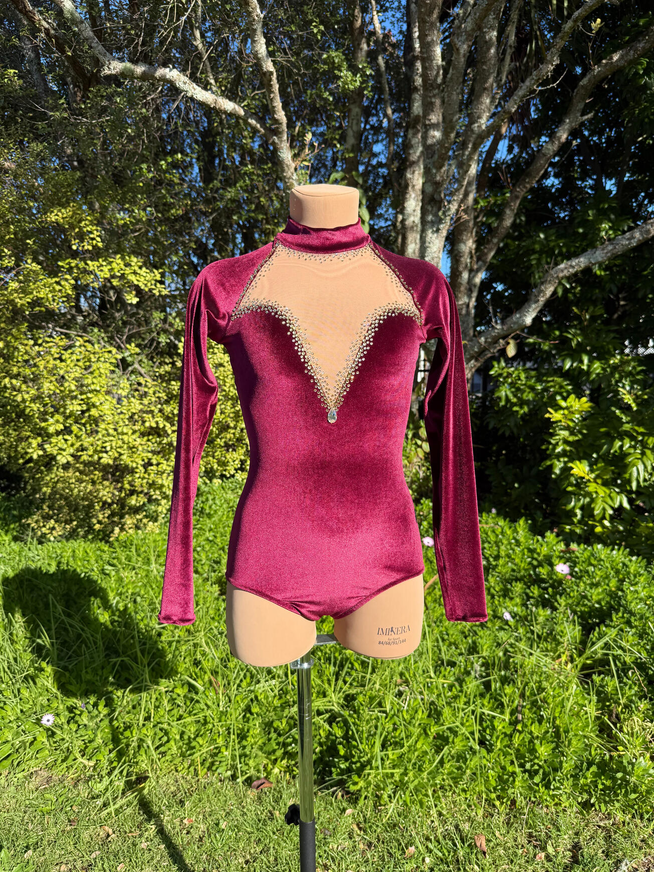 Velvet Rhythmic Gymastics Leotard Deep red/burgundy velvet rhythmic gymnastics leotard with gold rhinestones in three shades. Sweetheart neckline in nude mesh with a velvet turtle neck. This is an entry-level custom piece.